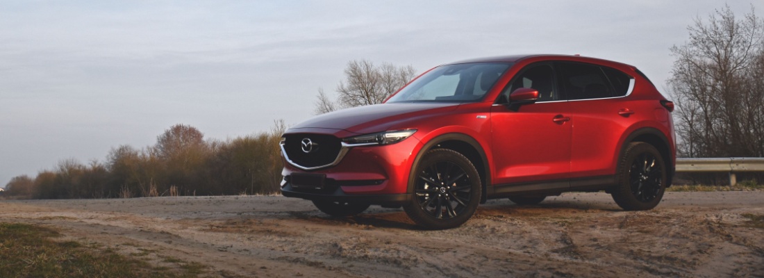 Red Mazda vehicle on road